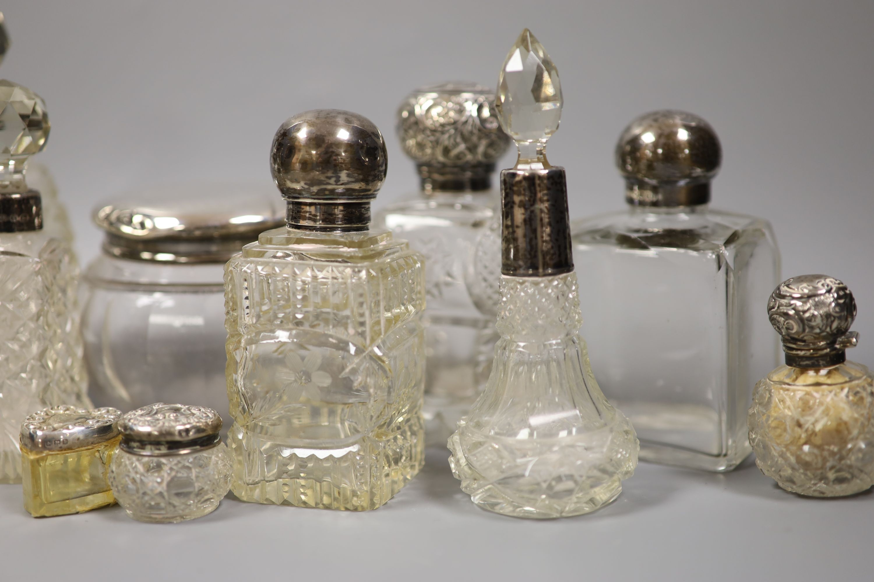 A collection of assorted silver mounted glass scent bottles, toilet jars etc. (a.f.)